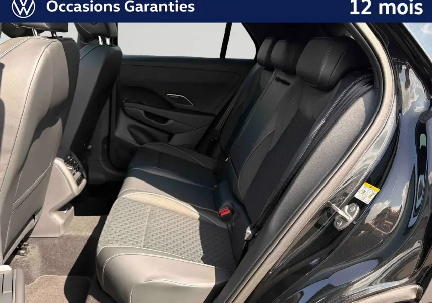 Vue intérieure côté droit des sièges arrière en cuir noir et tissu du Volkswagen T-Roc 2026 avec porte ouverte.