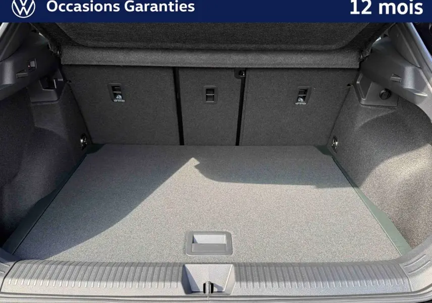 Coffre ouvert du Volkswagen T-Roc noir, vue intérieure montrant l'espace de chargement et la moquette grise.