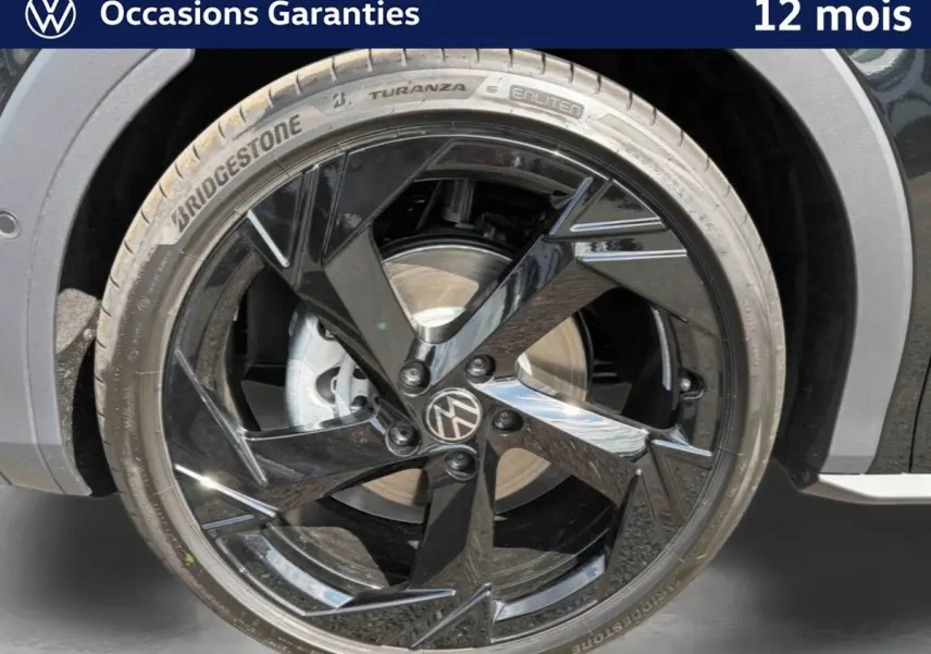 Gros plan sur la jante noire brillante 20 pouces du Volkswagen T-Roc 2026, avec pneu Bridgestone et logo VW central.