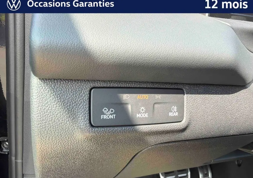 Détail du tableau de bord noir du Volkswagen T-Roc 2026 avec commandes d’éclairage automatiques.