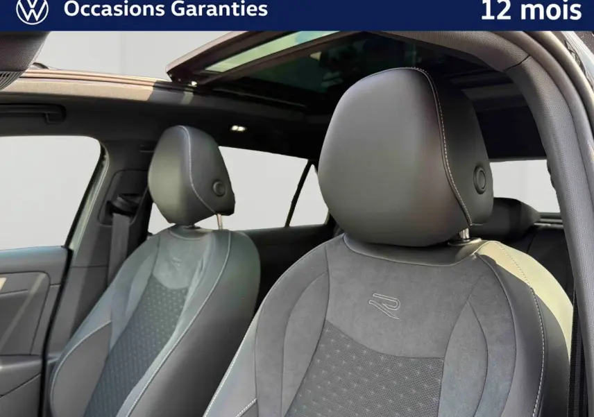 Gros plan sur les sièges avant en cuir noir avec surpiqûres blanches et toit ouvrant panoramique du Volkswagen T-Roc 2026.