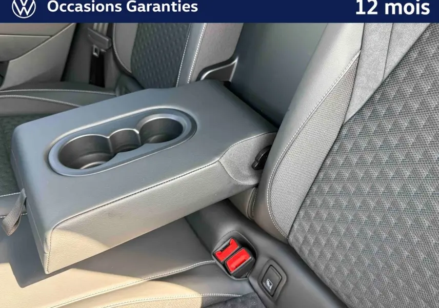 Détail de l'accoudoir central arrière avec porte-gobelets et sellerie tissu gris du Volkswagen T-Roc noir.