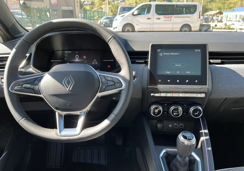 Intérieur de la Renault Clio V Facelift TCe 90 Techno 2025, volant multifonction et écran tactile au centre, boîte manuelle visible.