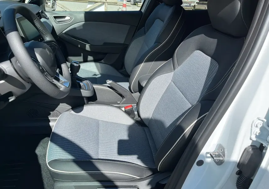 Intérieur de la Renault Clio V Facelift TCe 90 Techno 2025, vue côté conducteur, sièges tissu gris et cuir noir.