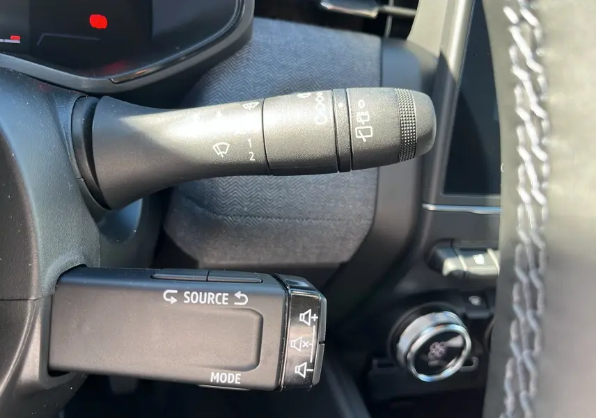 Gros plan sur la commande de régulateur et essuie-glace dans l'habitacle d'une Renault Clio blanc 2025.