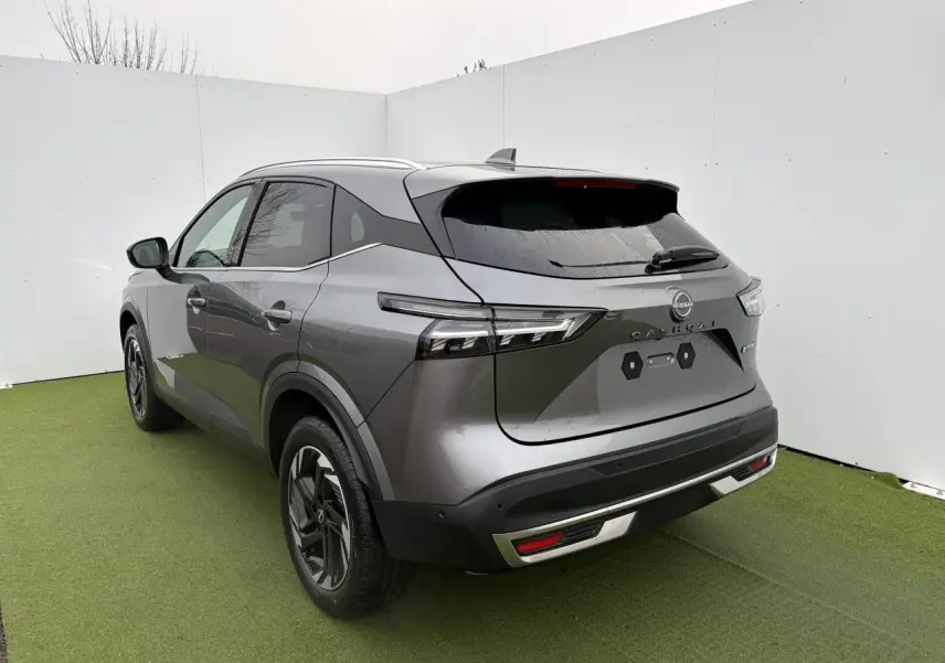 Vue 3/4 arrière droite du Nissan Qashqai III 2025 gris foncé métallisé avec feux LED et jantes alliage 18 pouces.