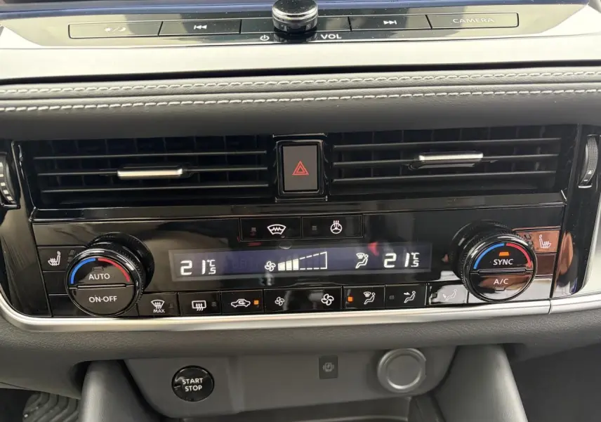 Gros plan sur la console centrale du Nissan Qashqai 2025, affichage digital de la climatisation bi-zone et commandes tactiles.