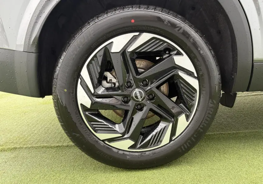 Gros plan sur la jante alliage 18 pouces bicolore noir et argent du Nissan Qashqai III gris foncé.