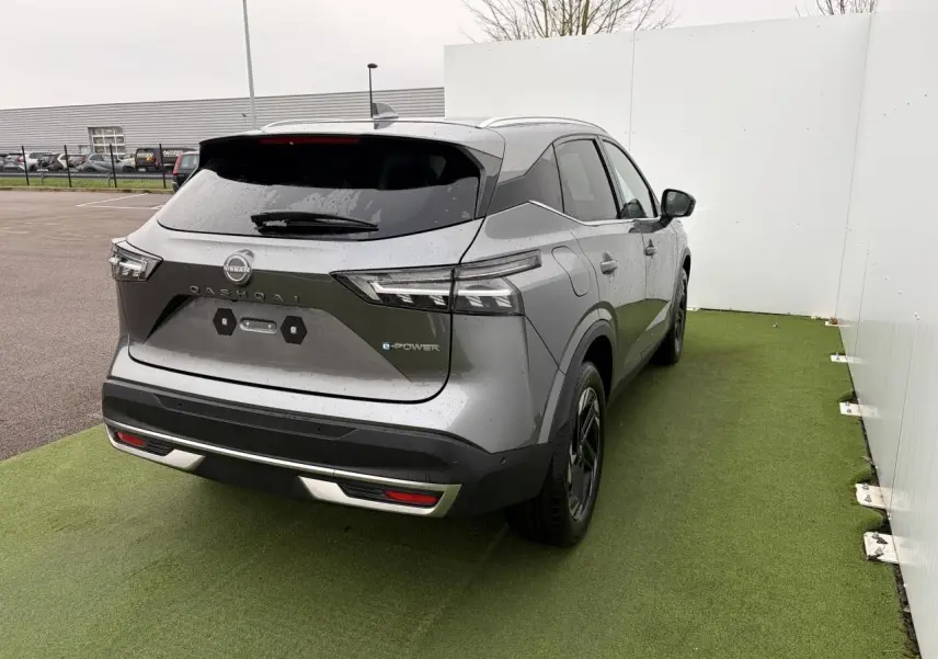 Vue 3/4 arrière droite du Nissan Qashqai III 1.5 Hybrid e-Power gris foncé métallisé avec badges e-POWER et vitres teintées.
