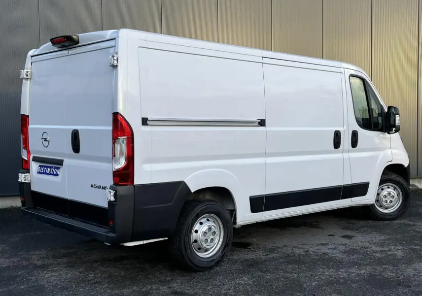 Vue 3/4 arrière droite d’un fourgon Opel Movano blanc avec porte latérale coulissante et jantes acier.
