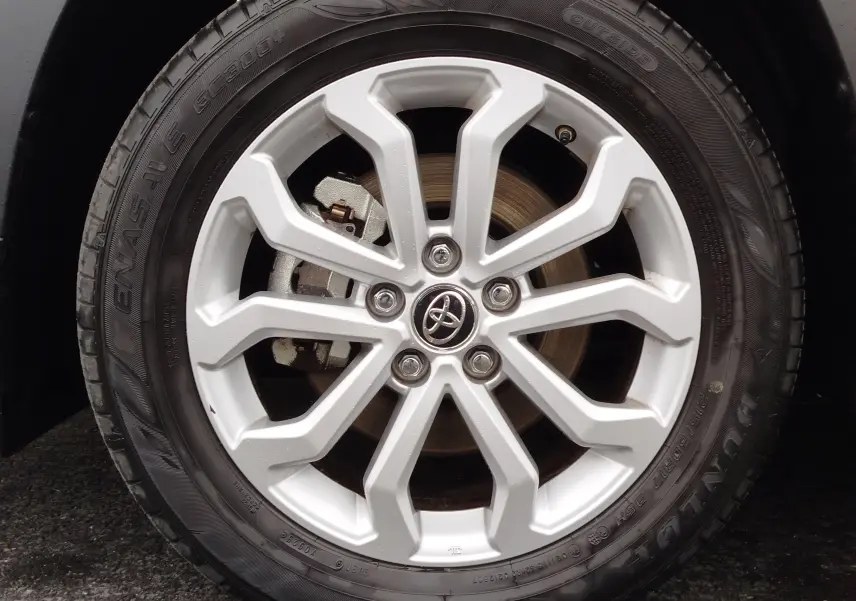 Gros plan sur la jante argentée en alliage du Toyota Corolla Cross 2025 noir intense, avec logo Toyota au centre.