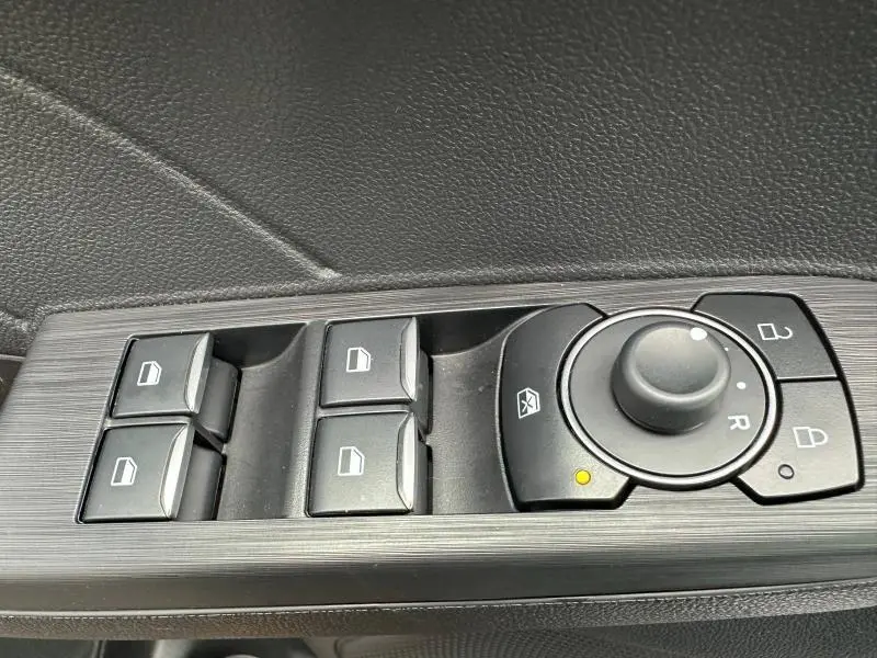 Commande des vitres électriques et réglage des rétroviseurs côté gauche dans un Ford Kuga gris Solar 2024.
