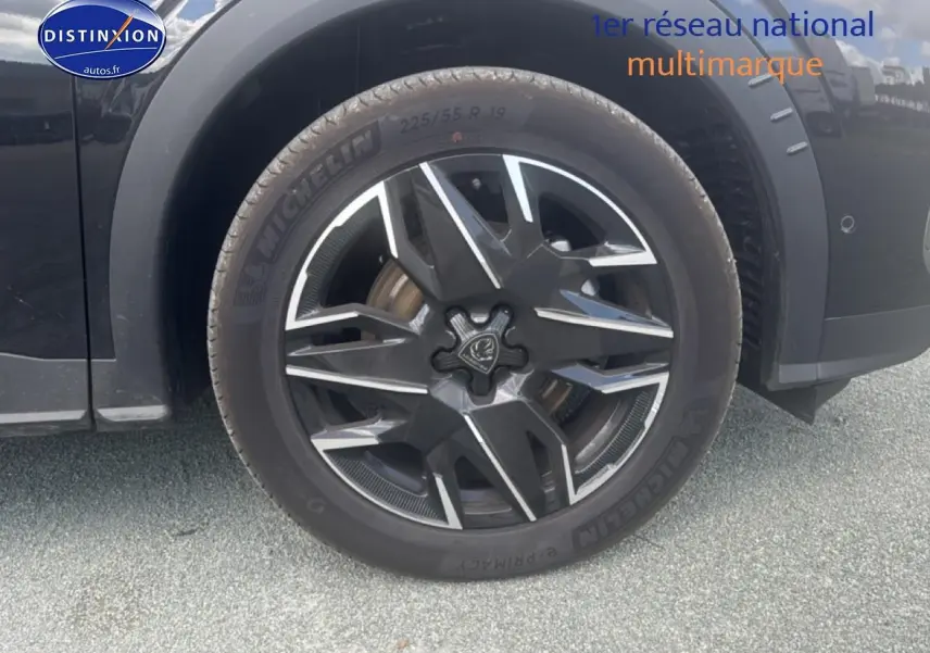 Gros plan sur la roue avant droite noire du Peugeot 5008 Hybrid 145 allure e-dcs6 avec jante alu distinctive.