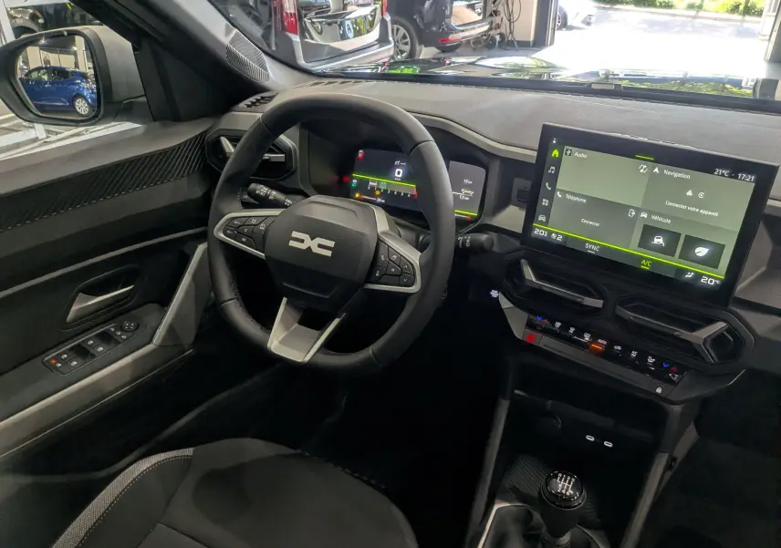 Vue intérieure côté conducteur du Dacia Bigster 2026, tableau de bord numérique et écran tactile central avec boîte manuelle.