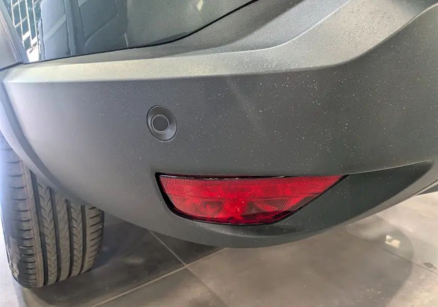 Gros plan sur le feu arrière droit rouge et le pare-chocs vert cèdre du Dacia Bigster Mild Hybrid 2026.