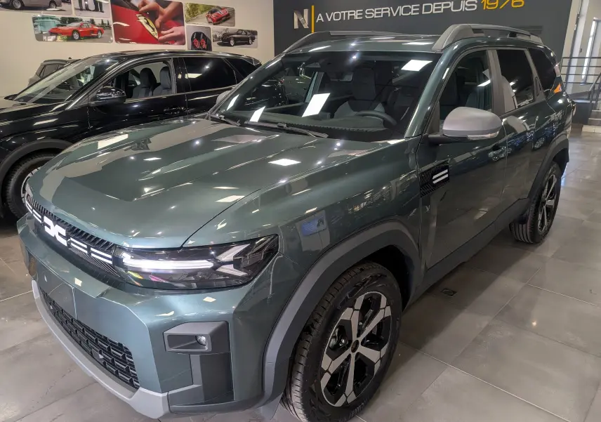 Vue 3/4 avant droite du Dacia Bigster Vert Cèdre 2026 avec jantes bi-ton et détails noirs contrastants.