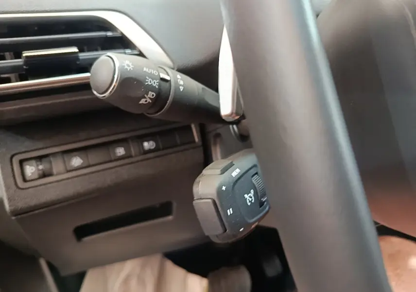 Détail du volant cuir et commandes au volant du Peugeot 3008 hybride rechargeable bleu, vue côté gauche intérieure.