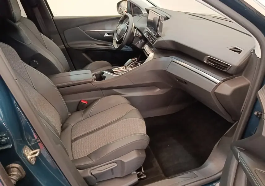 Vue intérieure côté passager du Peugeot 3008 bleu 2023, montrant sièges tissu/cuir et tableau de bord moderne.