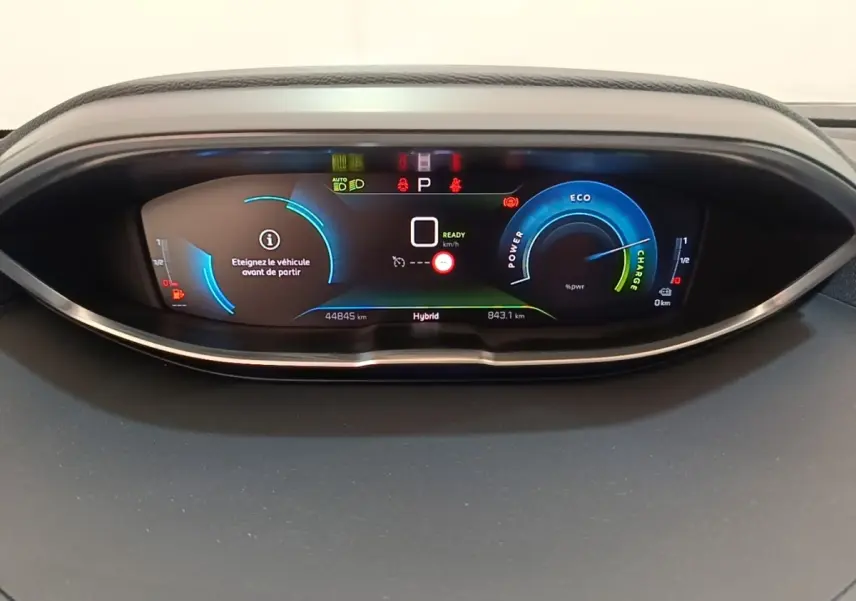 Vue rapprochée du tableau de bord numérique du Peugeot 3008 hybride rechargeable 2023, affichage couleur et indicateurs LED.