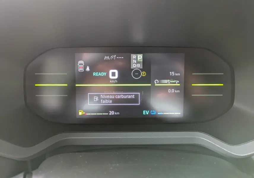 Tableau de bord numérique du Dacia Duster Hybrid 155 Extreme affichant un message de niveau carburant faible.