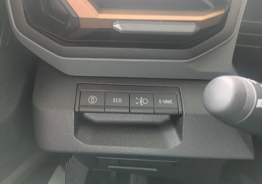 Gros plan sur les boutons de commande du tableau de bord du Dacia Duster Hybrid 155 Extreme, intérieur noir.