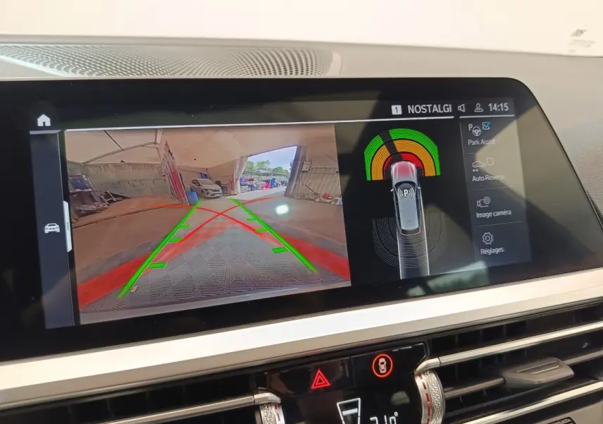 Écran tactile central de BMW Série 3 320e hybride montrant la caméra de recul et l'assistance au stationnement.