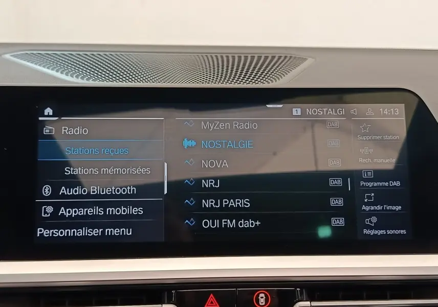 Écran tactile central affichant les stations radio DAB dans l’habitacle d’une BMW Série 3 320e gris foncé.
