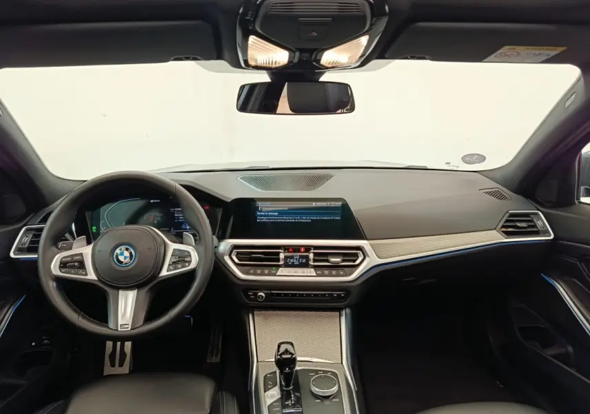 Vue intérieure avant de la BMW Série 3 320e M Sport 2022, tableau de bord moderne avec écran tactile et volant cuir noir.