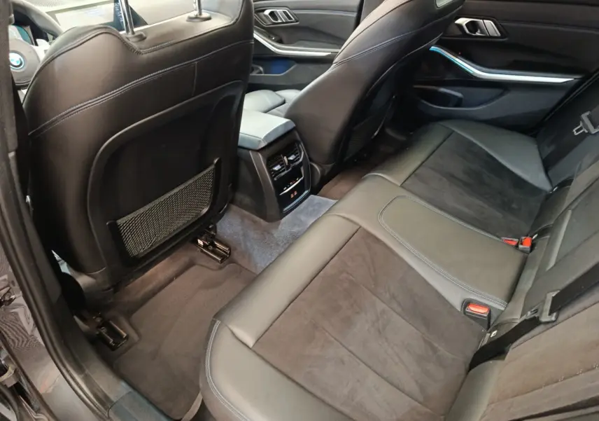 Vue intérieure arrière côté droit de la BMW Série 3 320e M Sport 2022 avec sièges cuir noir et console centrale.