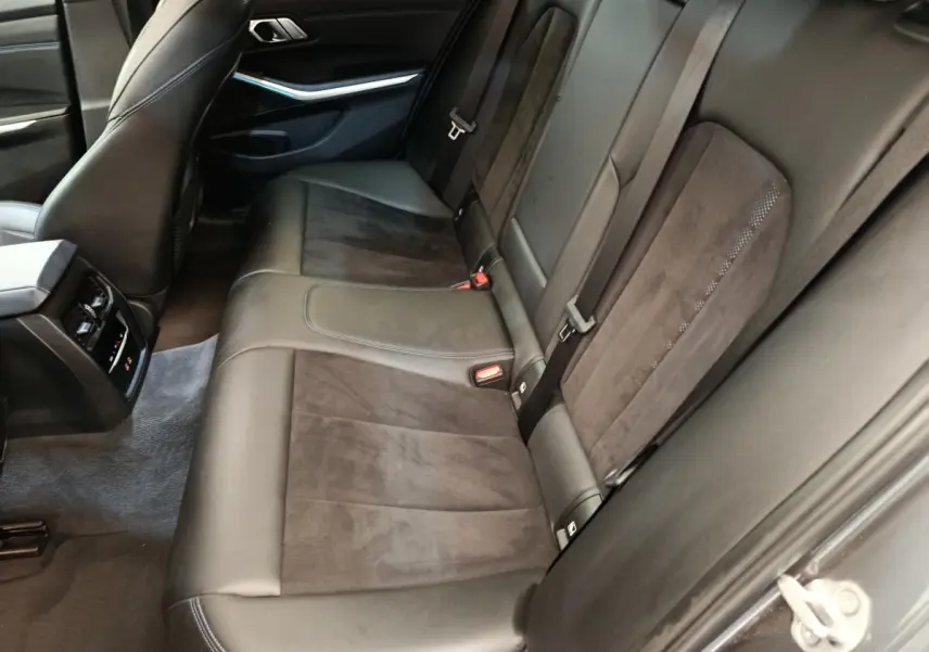 Vue côté droit de la banquette arrière en cuir noir et alcantara d’une BMW Série 3 320e M Sport 2022.