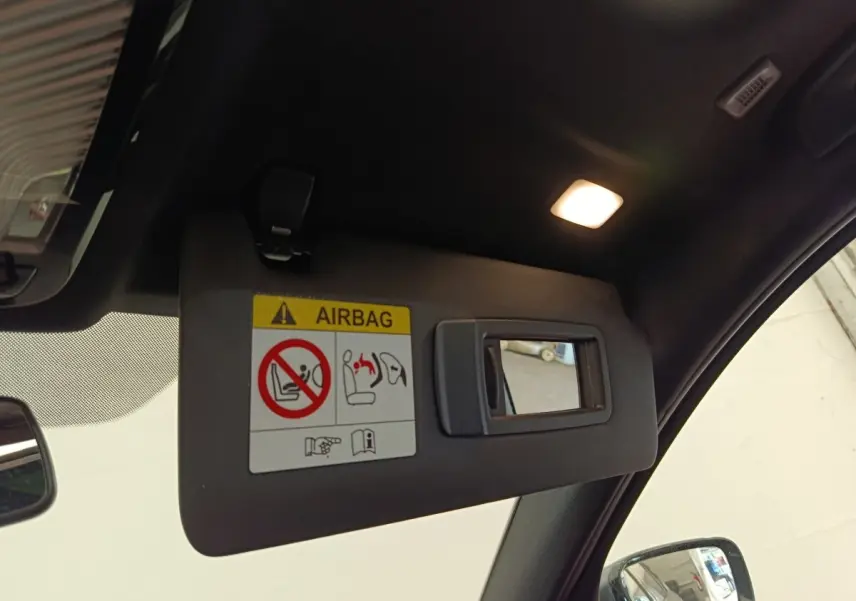 Détail du pare-soleil côté conducteur avec miroir intégré et lumière dans une BMW Série 3 gris foncé hybride rechargeable.