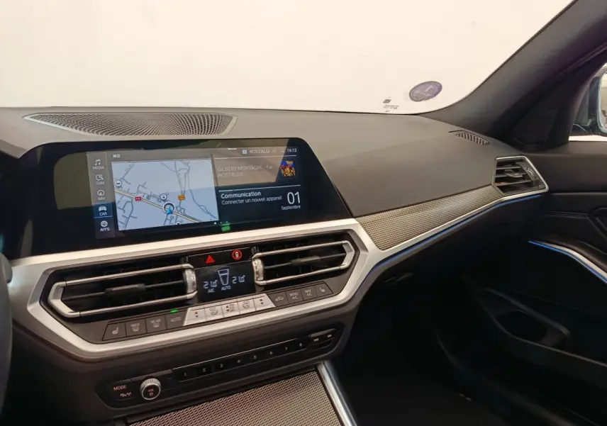 Vue intérieure côté passager de la BMW Série 3 320e M Sport 2022, tableau de bord avec écran tactile et finitions gris foncé.