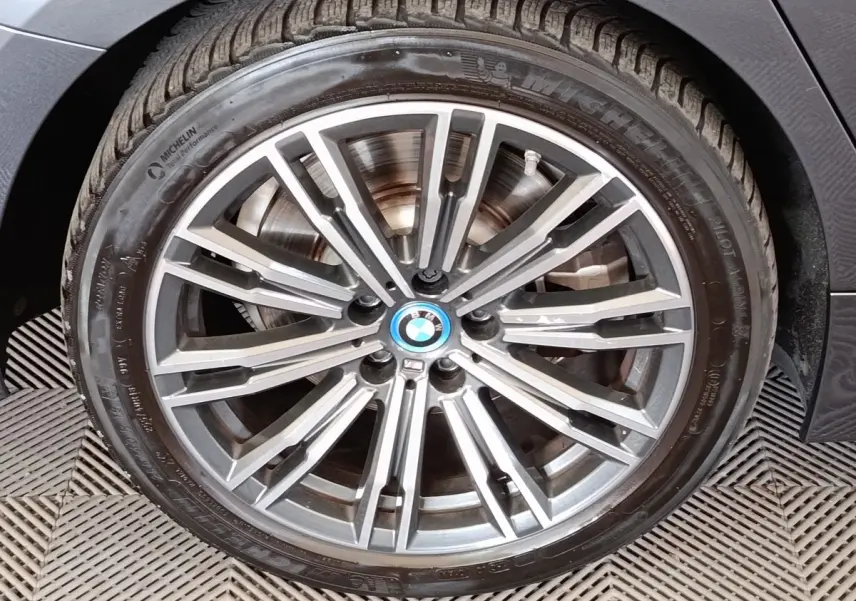 Gros plan sur la roue avant droite d'une BMW Série 3 320e M Sport gris foncé avec jante alliage multi-branches.