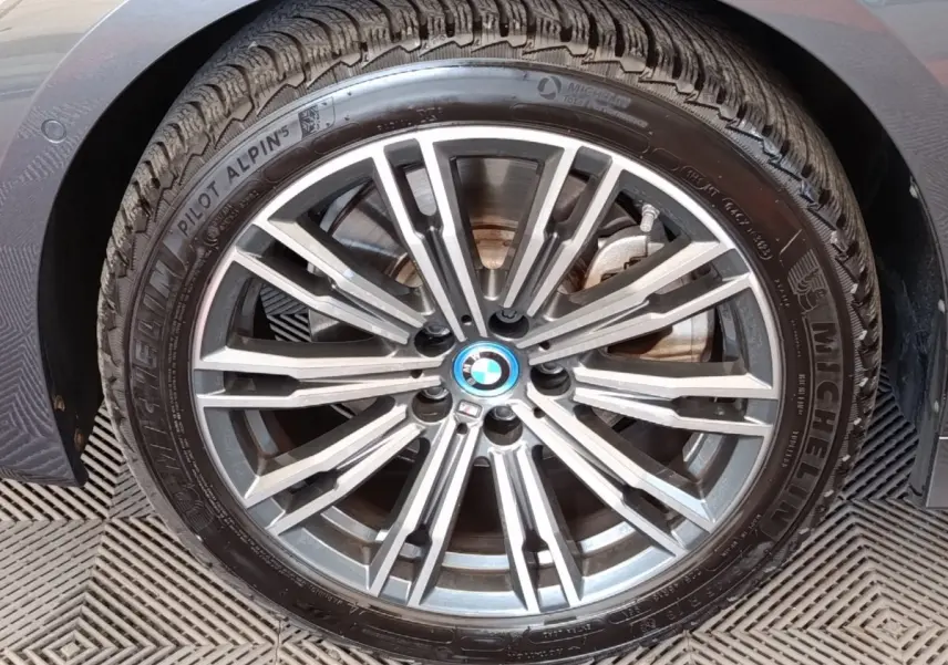 Gros plan sur la jante alliage gris et le pneu Michelin d’une BMW Série 3 320e gris foncé, vue côté gauche.