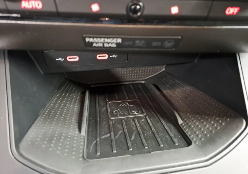 Gros plan sur la zone de recharge sans fil et ports USB-C rouges dans l’habitacle du SEAT Arona 2024.