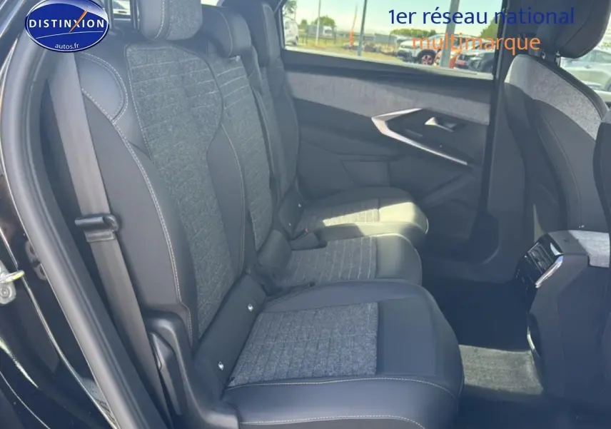 Vue latérale droite de l'intérieur arrière du Peugeot 5008 noir, montrant les sièges en tissu et cuir gris.