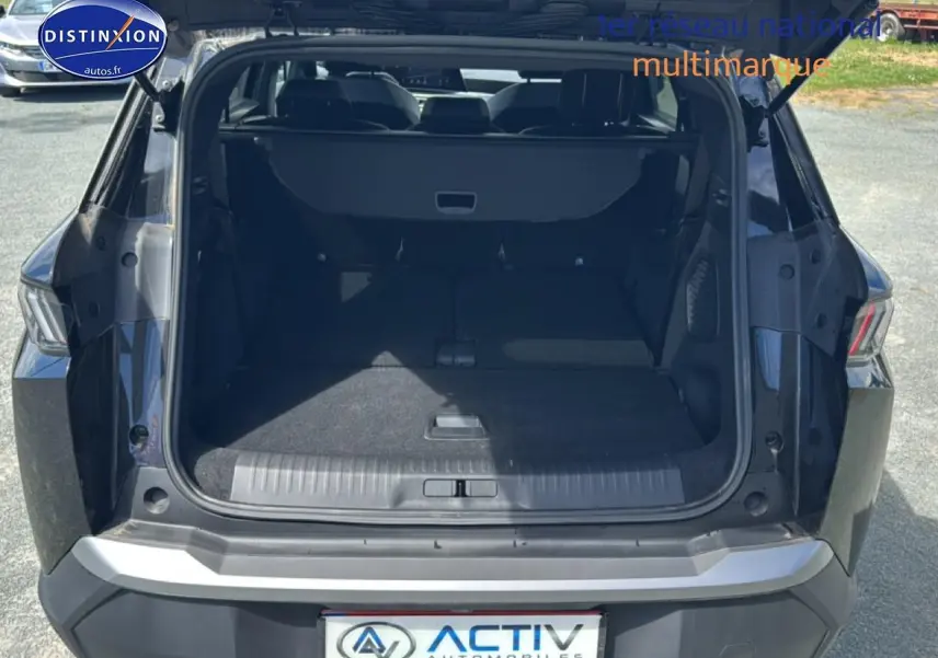 Coffre ouvert en vue arrière d’un Peugeot 5008 Hybrid 145 allure e-dcs6 noir, montrant l’espace de chargement.