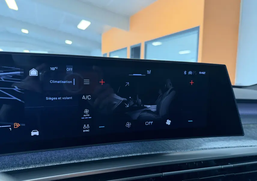 Écran tactile du tableau de bord du Peugeot 3008 Hybrid 145 GT montrant les réglages de climatisation et sièges chauffants.