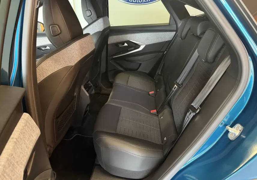 Vue intérieure arrière droite du Peugeot 3008 Hybrid 145 GT bleu obsession, sièges tissu noir et gris avec surpiqûres claires.