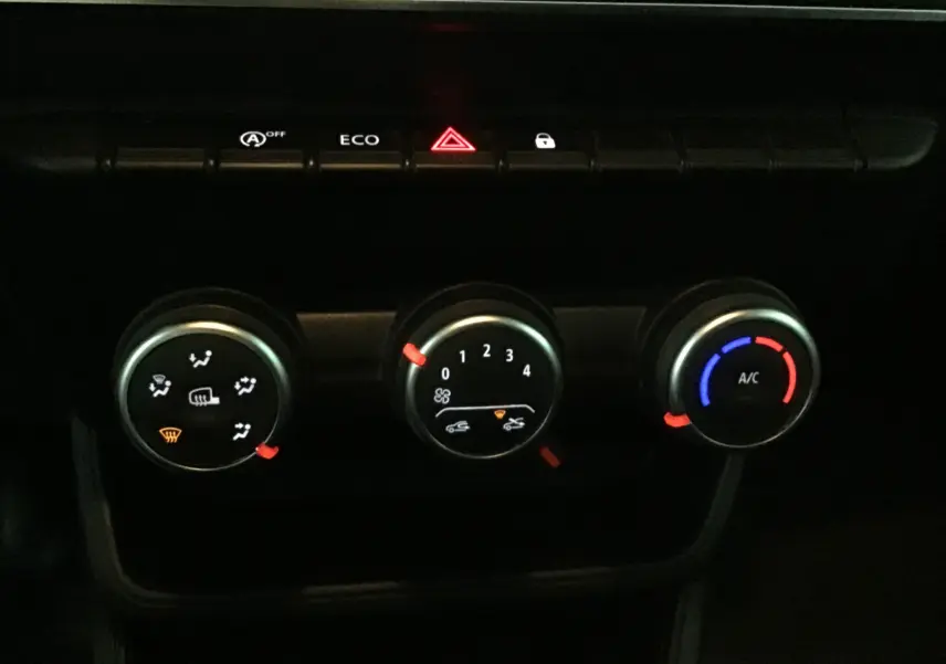 Gros plan sur les commandes de climatisation du Renault Express Van blanc 2023, avec boutons éclairés et indicateurs rouges et bleus.