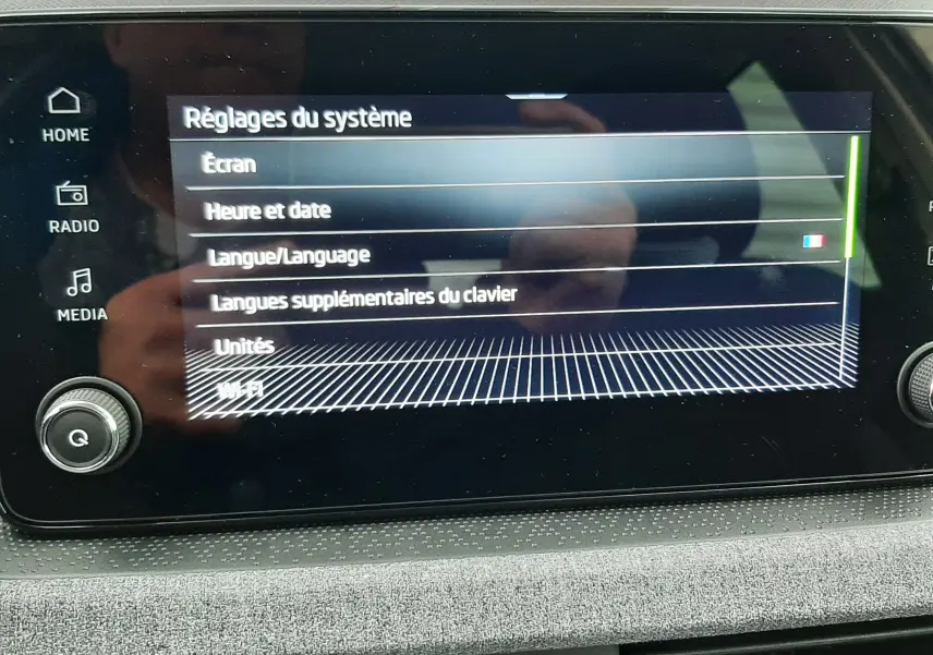 Écran tactile central du Skoda Kamiq 2025 affichant les réglages système avec commandes autour et finition tissu gris.