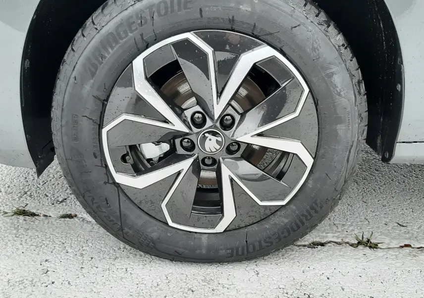 Gros plan sur la roue avant droite du Skoda Kamiq gris graphite, mettant en valeur la jante au design géométrique moderne.
