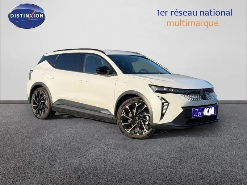 Vue 3/4 avant droite d'un Renault Scénic E-Tech électrique blanc, avec jantes noires et détails noirs contrastants.