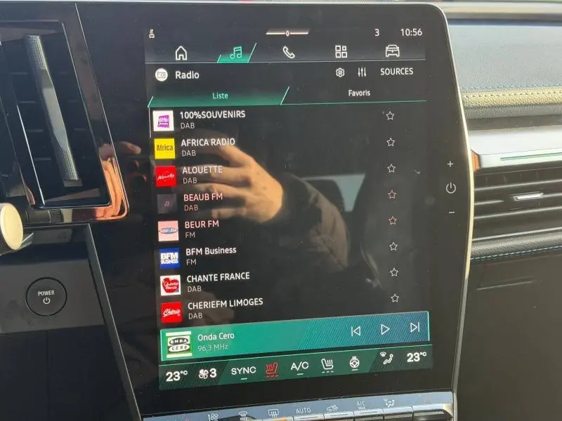 Écran tactile central du tableau de bord du Renault Scénic blanc 2025, affichant la liste des radios DAB.