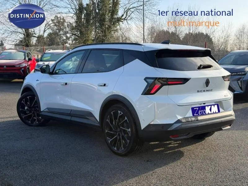 Vue 3/4 arrière droite d'un Renault Scenic E-Tech électrique blanc avec toit noir et jantes noires distinctives.