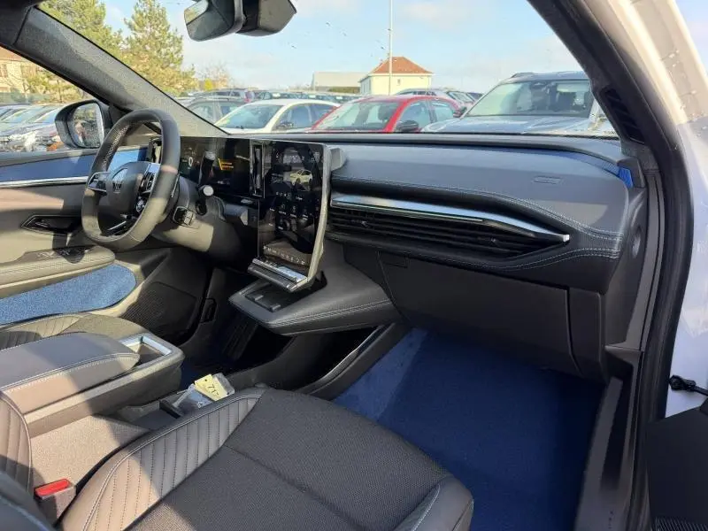 Intérieur côté conducteur du Renault Scénic E-Tech Electric blanc 2025, avec tableau de bord moderne et écran tactile vertical.