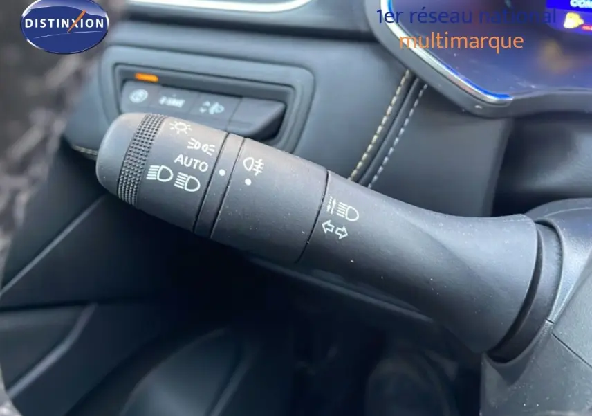 Gros plan sur la commande des feux et clignotants à gauche du volant dans l’habitacle du Renault Symbioz gris Casiopee Metal.