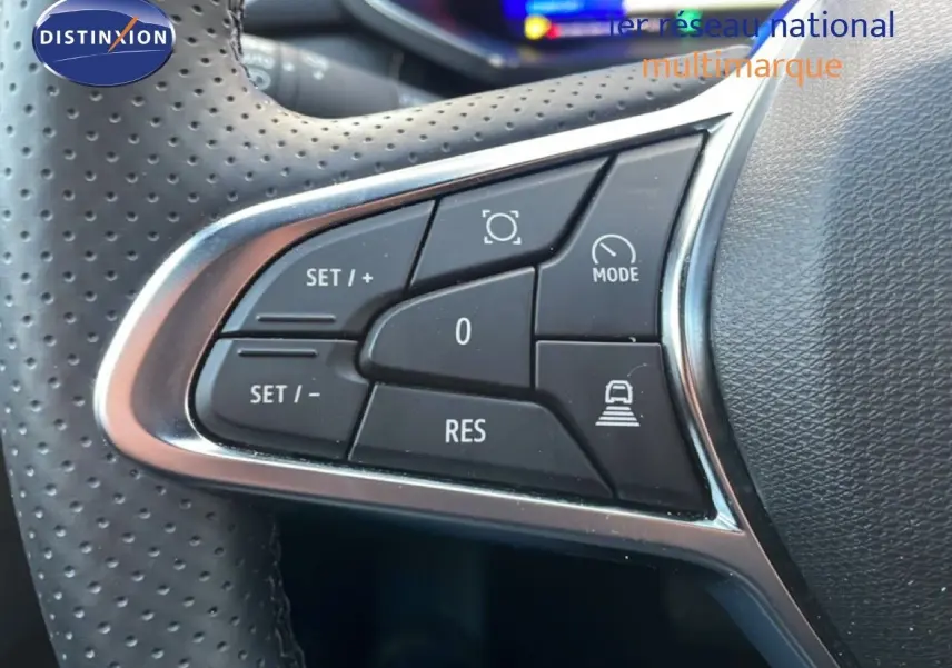 Gros plan sur les commandes de régulateur de vitesse au volant perforé du Renault Symbioz gris Casiopee Metal.
