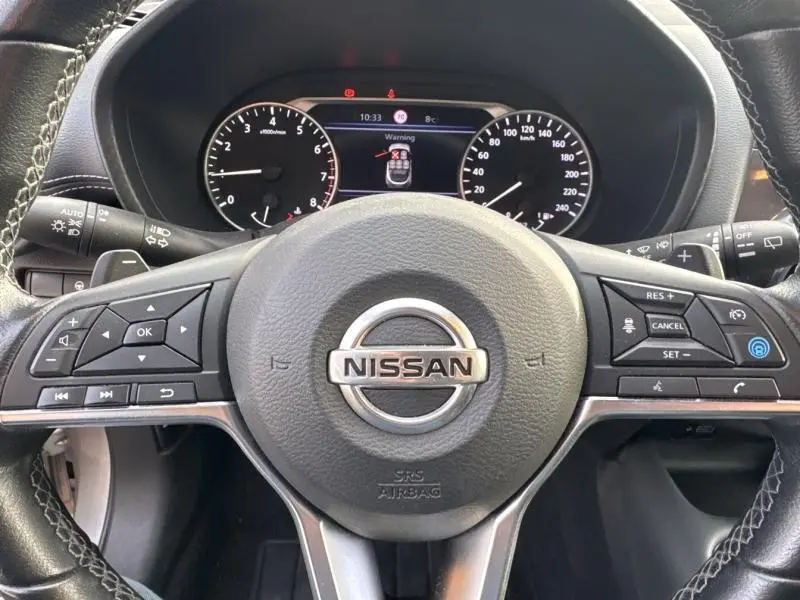 Vue rapprochée du volant cuir multifonction et du tableau de bord numérique du Nissan Juke gris perle 2022.
