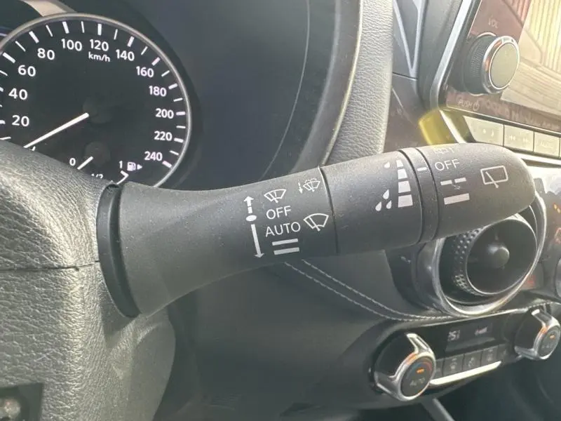 Gros plan sur la commande d’essuie-glace côté droit du tableau de bord d’un Nissan Juke gris perle métallisé 2022.